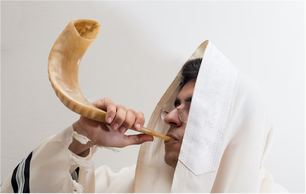 Man blowing a ram's horn shofar
